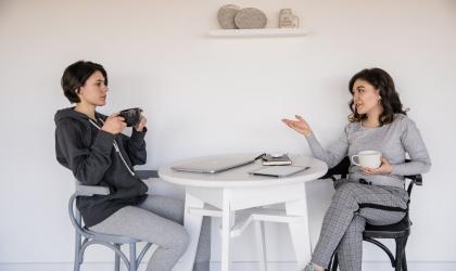Vrouwen praten met koffie in de hand
