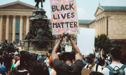 Een man houdt een bord vast met Black Lives Matter