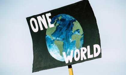 Protestbord planeet aarde plus tekst One World