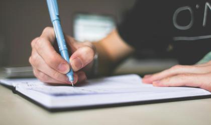 Persoon schrijft in notitieboekje