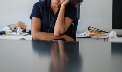 Vrouw zit verveeld achter haar bureau
