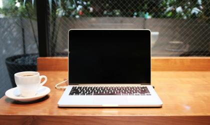 Macbook op bureau met kopje ernaast